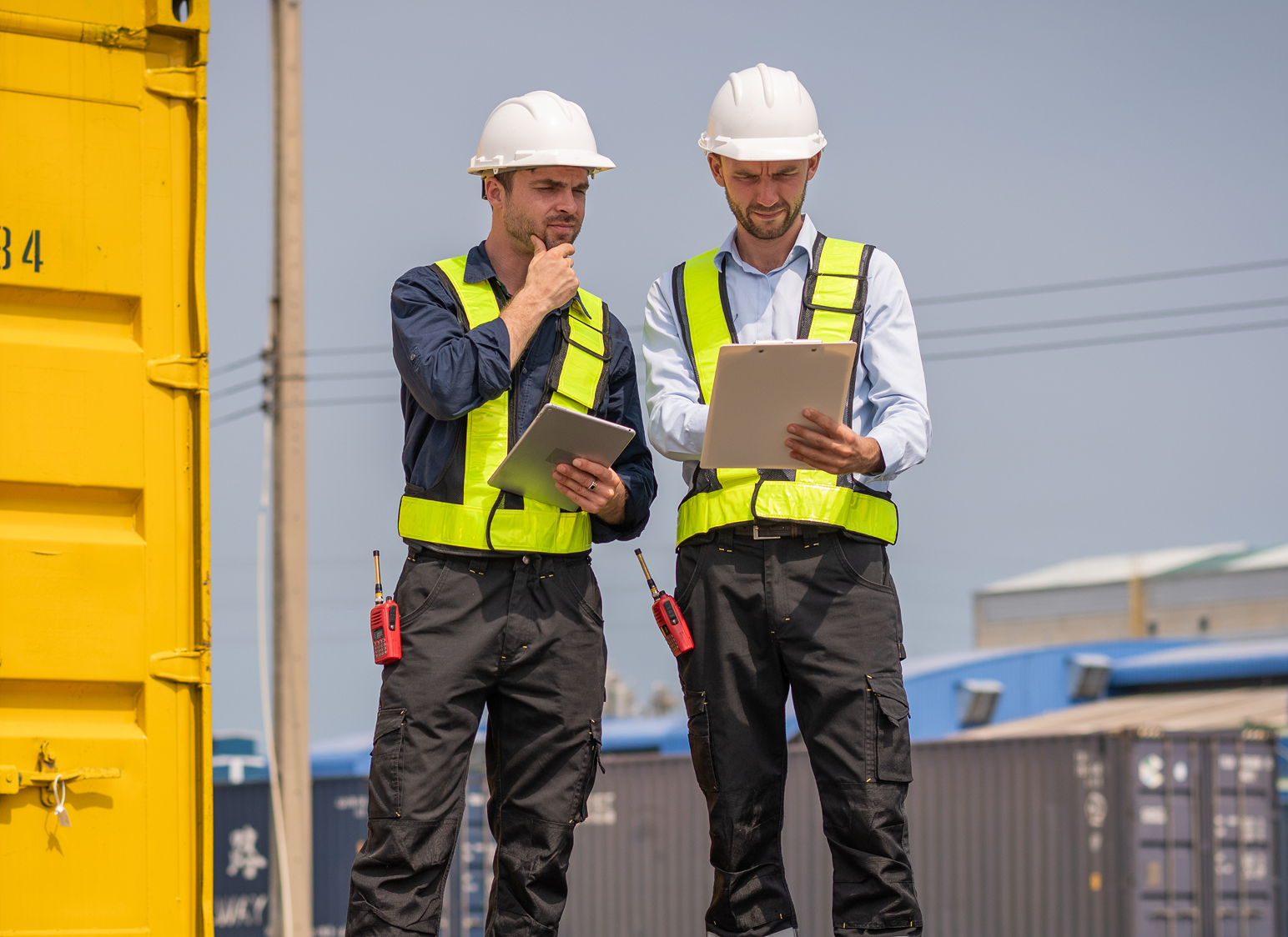 Workers in safety gear with tablets