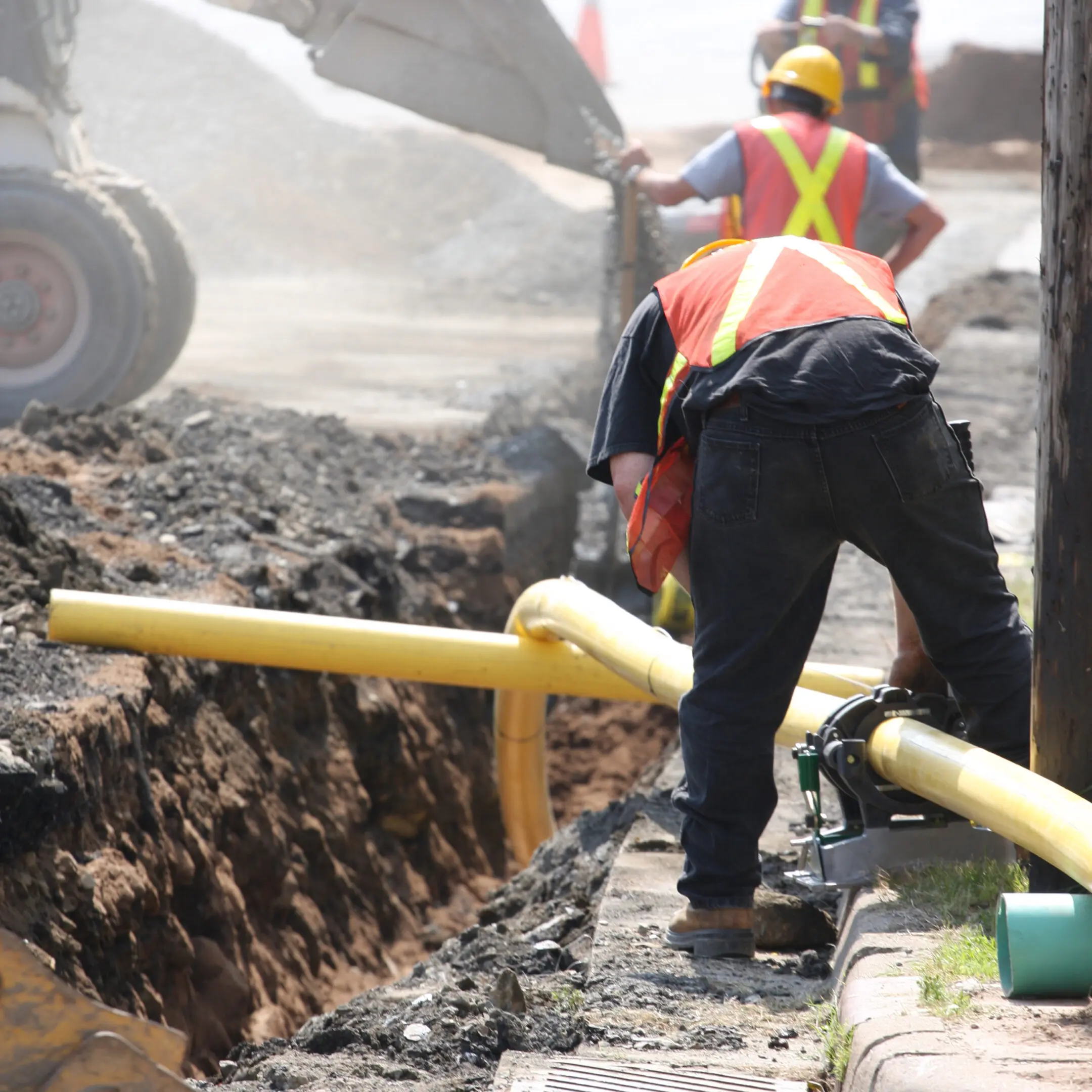Construction workers installing underground pipes