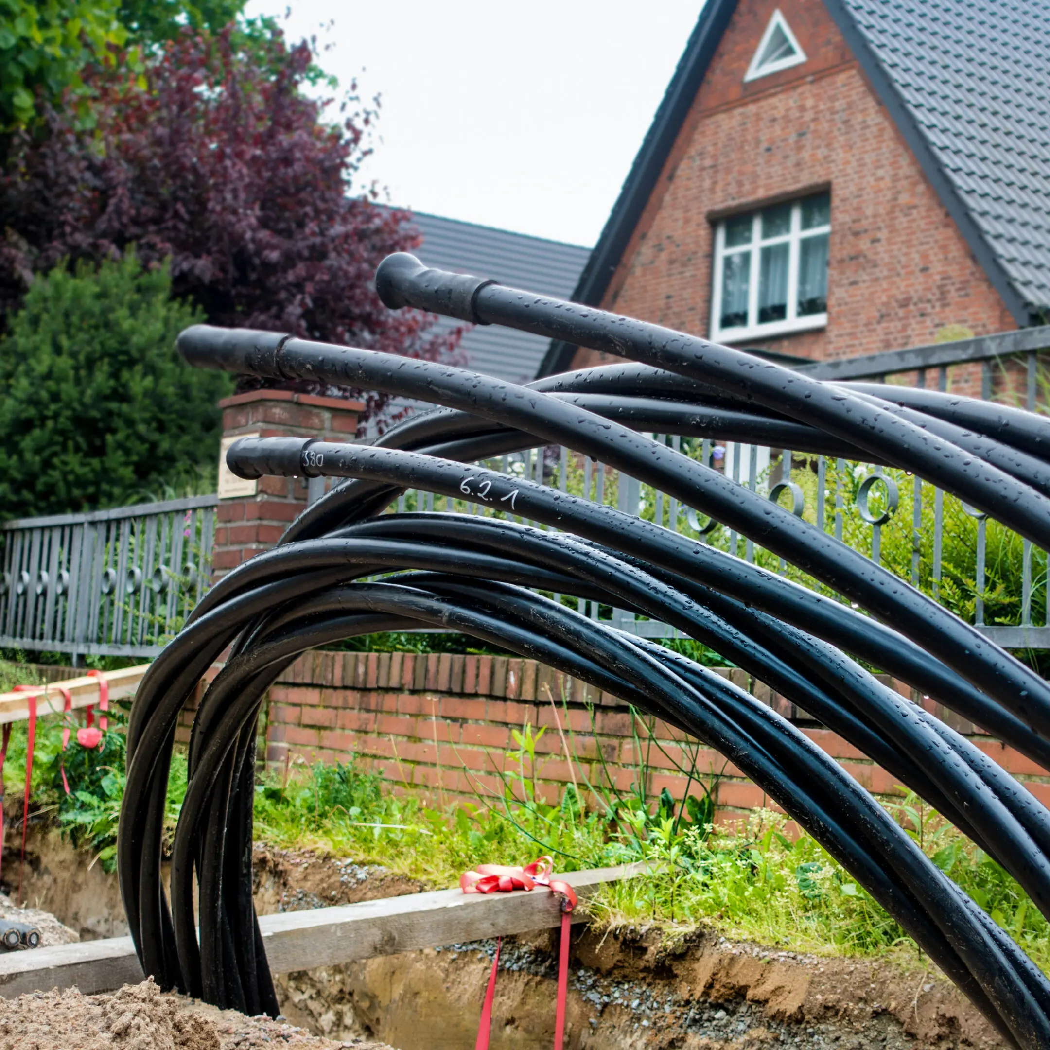 Underground cable installation near brick house