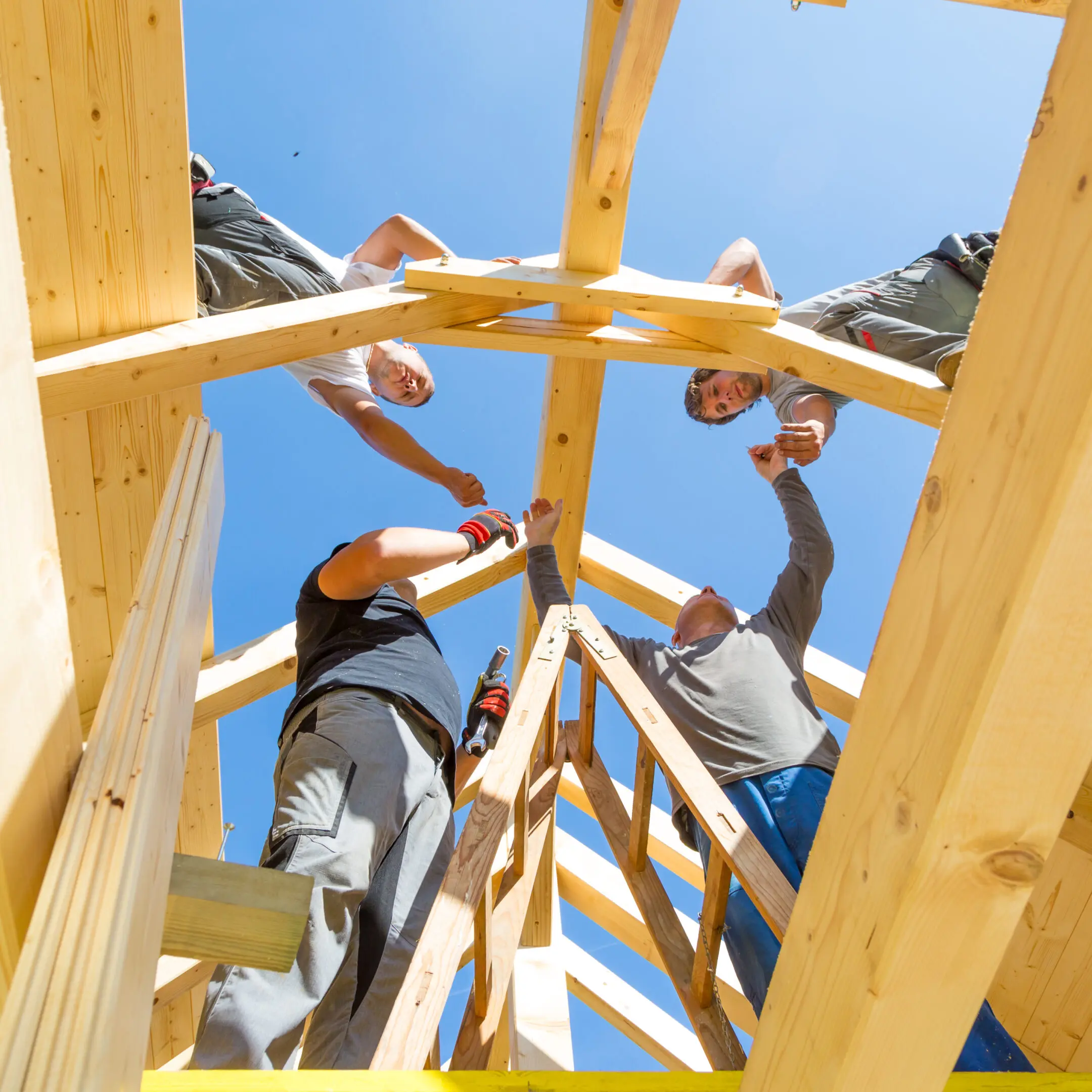 Construction workers building wooden roof frame